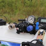 Inline strainer attached to an Everflo 12-volt pump on a Master Manufacturing ATV broadcast sprayer
